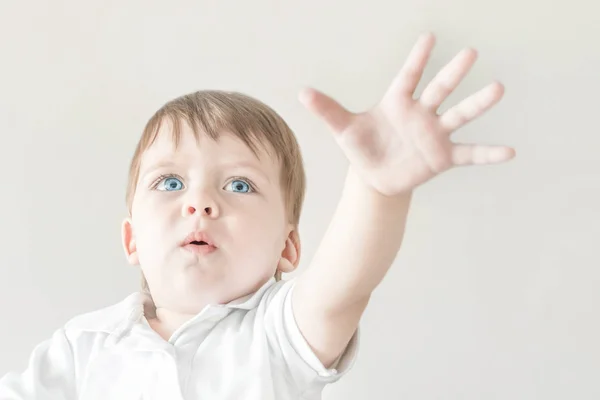 Loira de olhos azuis bebê puxa a mão aberta palma . — Fotografia de Stock