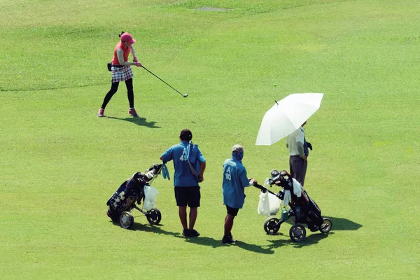 Golfer an einem sonnigen Tag kickt das Mädchen den Ball. — Stockfoto