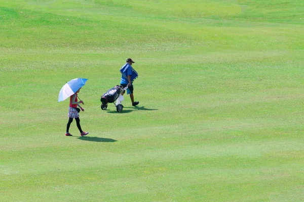 Golfer gehen über den grünen Golfplatz. — Stockfoto