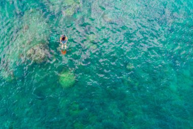 Genç bir kadın tropik gölde şnorkelle yüzüyor..