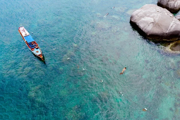 Boot und Taucher segeln in der Nähe der felsigen Küste, Blick von oben. — Stockfoto