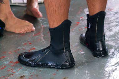 Neoprene dalış botları dalgıcın ayağında.