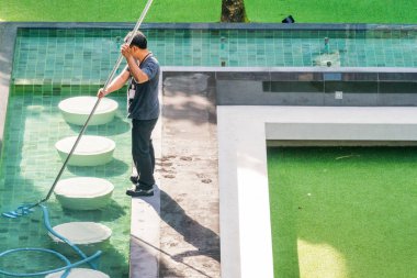 Havuz temizliği. İşçi otelin yakınındaki havuzu temizliyor..