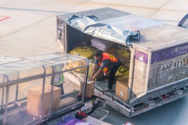 Phuket, Tayland - 3 Mart 2018: Erkek işçi kutuları boşaltıyor 