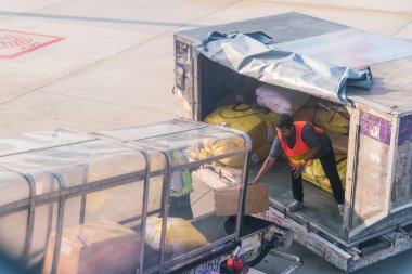 Phuket, Tayland - 3 Mart 2018: İşçi kutuları ve paketleri boşaltıyor