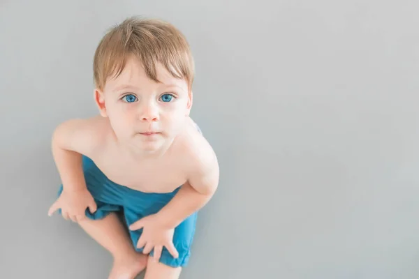 Bebe Garcon Blonde Aux Yeux Bleus En Short Bleu Assis Sur Un Fond Gris Personnes Le Bonheur Stock Photo Bebe Garcon Blonde Aux Yeux Bleus En Short Bleu Assis Sur Un Fond Gris Personnes Le Bonheur Stock Photo