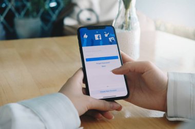 CHIANG MAI, THAILAND 25 JUL 2020: Sosyal İnternet hizmet Facebook 'u olan iPhone X' i elinde tutan kadın