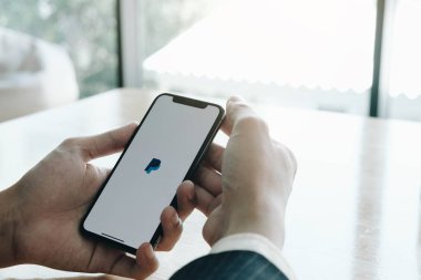 CHIANG MAI, THAILAND - 25 Temmuz 2020: Ekranda PayPal uygulamalı iPhone X 'leri tutan kadın. PayPal bir çevrimiçi elektronik ödeme sistemidir.