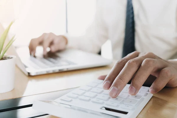 İşadamı, matematik finansmanı için hesap makinesi ve dizüstü bilgisayar kullanarak ofis ve iş geçmişi, vergi, muhasebe, istatistik ve analitik araştırma konseptini kapatır.