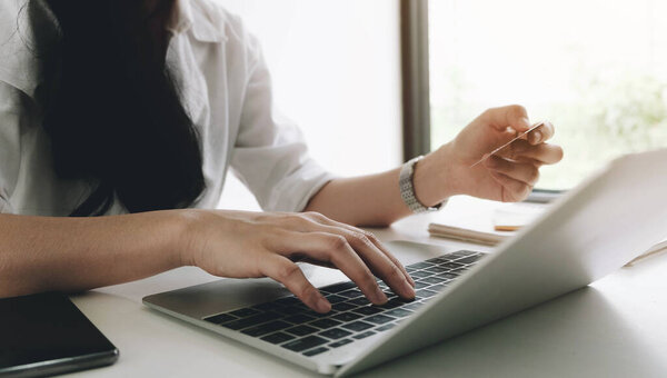 Online payment,woman's hands holding smartphone and using credit card for online shopping