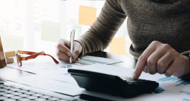Matematik finansmanı için hesap makinesi ve dizüstü bilgisayar kullanan iş kadını ofis ve iş geçmişi, vergi, muhasebe, istatistik ve analitik araştırma konsepti