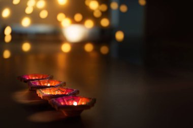 Renkli Diwali mumlarından oluşan bir yakın çekim bulanık arka planda yavaşça parlayan ılık bir festival atmosferi yaratıyor..