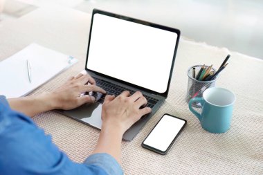 Uzaktan çalışan, bilgisayarında akıllı telefonu olan, modern iş-yaşam dengesini gösteren bir kişi..