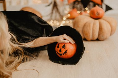 Cadılar Bayramı dekoru, cadı şapkalı balkabağı, cadı şapkası, balkabağı, korku, arka planda ışıklar.