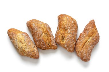 Dört taze pişmiş çörek, kıtır kıtır, beyaz bir arka planda izole edilmiş.