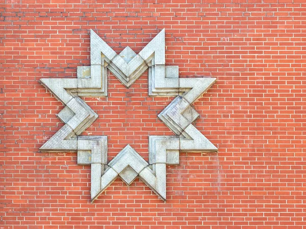 Ośmiokątna gwiazda granitu na ceglanej ścianie — Zdjęcie stockowe