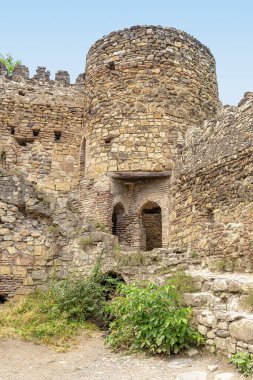 Gürcistan askeri yolundaki Eski Kale 'nin yuvarlak, köşe, silindirik kulesi, tuğlalardan, kayalardan ve büyük nehir taşlarından kale duvarları.