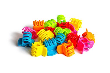 Beyaz arka planda izole edilmiş çok renkli plastikten yapılmış parlak saç tokaları.