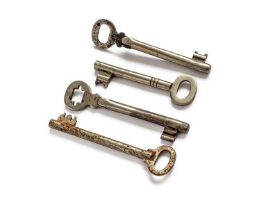 Farklı kayıp kilitlerden dört eski, eskimiş anahtar, beyaz bir arka planda izole edilmiş.