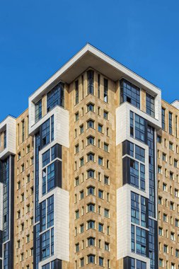 Pencereleri ve mavi gökyüzüne karşı jöleli loggiaları olan modern bir gökdelen.