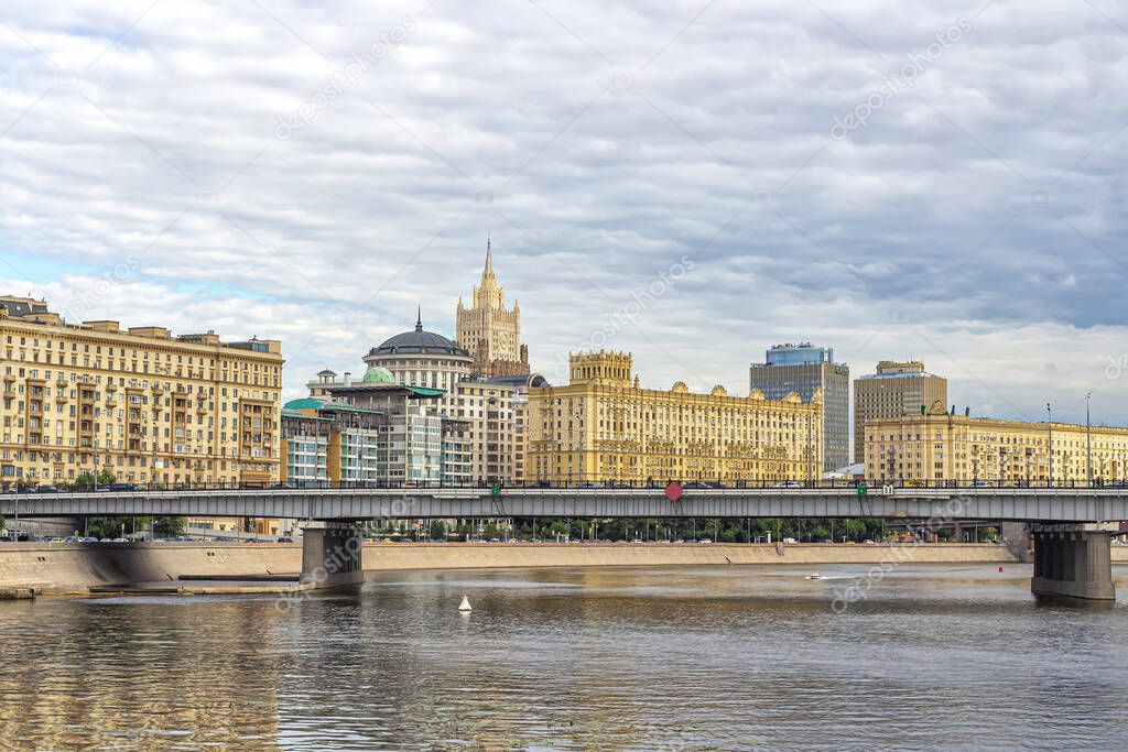Moscow, Russia, 08.07.2020. Novoarbatsky bridge over the Moscow river, Stalin's houses on the embankment, the British Embassy and the spire of the Ministry of foreign Affairs