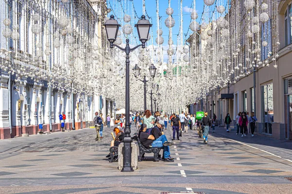 Moskova, Rusya, 08.21.2020. Nikolskaya Caddesi - Moskova 'nın merkezinde yaya turizm bölgesi, banklar, sayısız turist, gece aydınlatması için tepesinde ampuller vardı