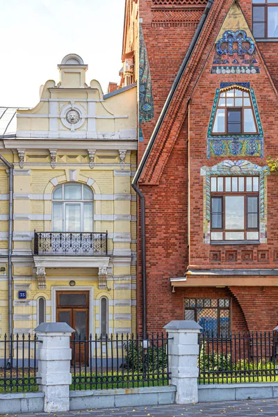 Moscow, Russia, 09.04.2020. Facades of houses in different architectural styles: brick house (Tsvetkova) in the Russian Empire style and yellow house in the neoclassical style