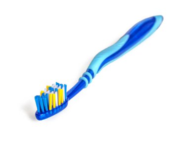 Mavi-beyaz-sarı tüylü, beyaz arkaplanda izole edilmiş, mavi tonda plastik diş fırçası.
