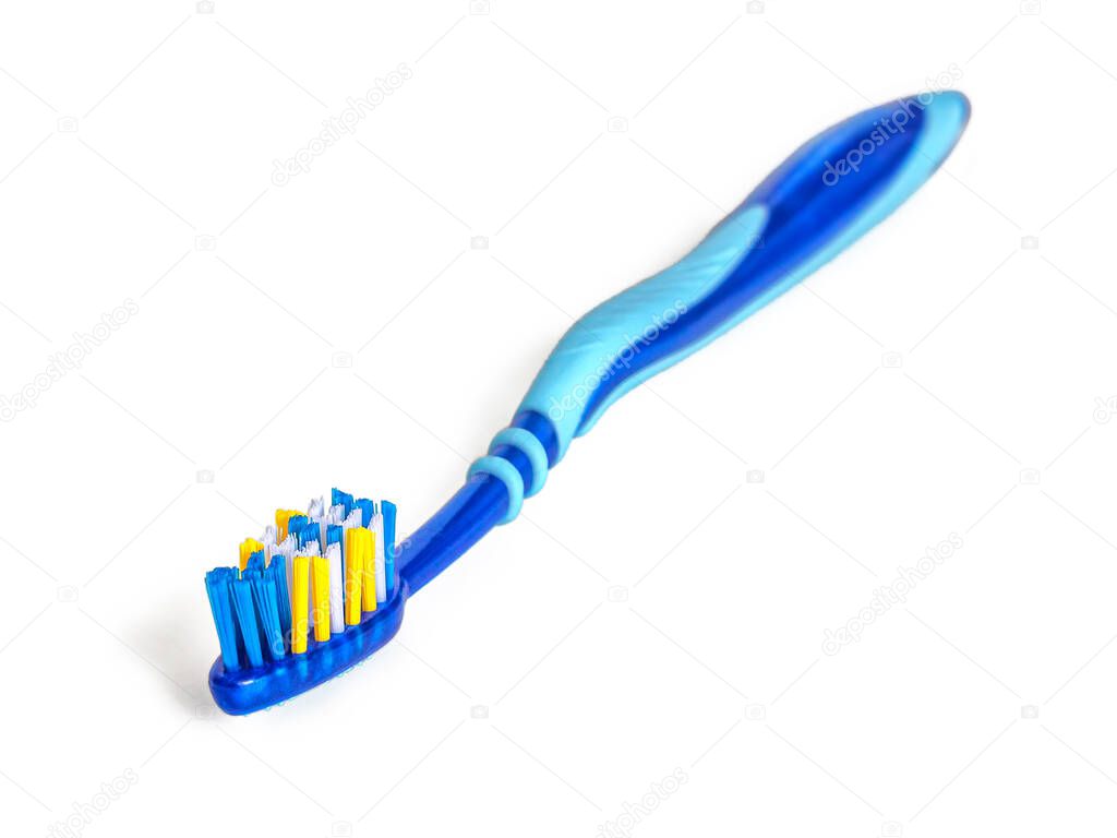 Plastic toothbrush in blue tones, with blue-white-yellow bristles, isolated on a white background