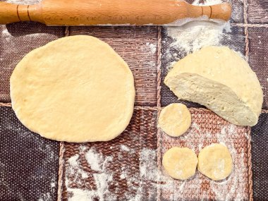 Ahşap bir yüzeyde çiğ hamur. Un ürünleri hazırlama süreci.