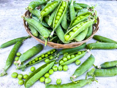 Soyut bir yüzeyde olgunlaşmış bezelye kabukları. Sağlıklı beslenme ve tarım kavramı. Boş alan. Işık arkaplanını sil.