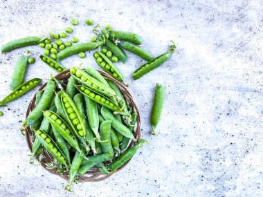 Soyut bir yüzeyde olgunlaşmış bezelye kabukları. Sağlıklı beslenme ve tarım kavramı. Boş alan. Işık arkaplanını sil.