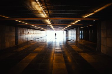 Tanımlanamayan kişinin silueti ve metro tünelinde gün ışığı.