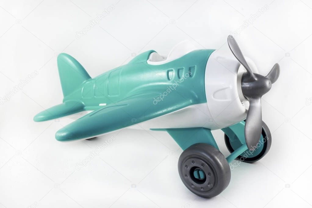 toy, plastic airplane with a propeller, without a pilot on a white background, turquoise brush, side view