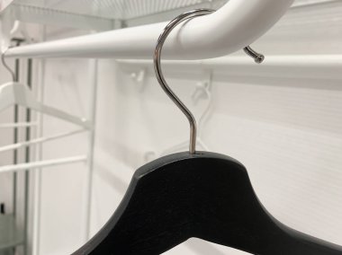 Dolapta boş siyah ahşap bir el çantası, metal bir tüpte asılı.