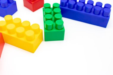 Birçok renkli oyuncak plastik tuğlalar, kopyalama alanı olan beyaz arkaplan üzerine inşa ve inşa etmek için blok kitleri