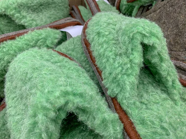 Banyak sandal hijau berbulu halus di sebuah toko, berbelanja untuk rumah yang nyaman — Stok Foto