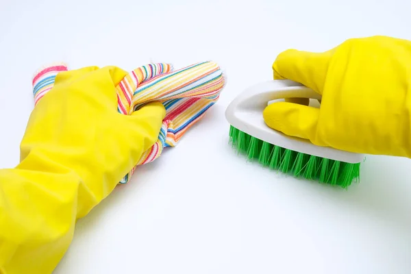 Gants en caoutchouc jaune nettoyant la surface blanche à l'aide d'une brosse et d'une lingette, concept de ménage et d'entretien ménager — Photo