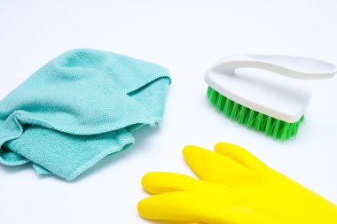 Beyaz yüzeyde sarı lastik eldivenler, fırça ve mikrofiber mendil, ev temizliği ve ev işi konsepti, ev hijyeni ve hijyenik koruma