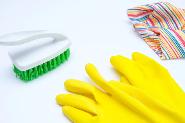 Gelbe Handschuhe mit grünem Pinsel und Mikrofasertuch auf weißem Hintergrund, Reinigungs- und Routinekonzept — Stockfoto