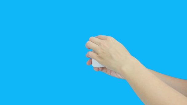 Vrouwelijke handen het openen van een witte plastic container met vitamine C dragee en giet pillen op een hand, palm tegen blauwe achtergrond — Stockvideo