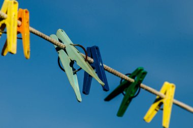 İpin arka planındaki renkli mandallar reklam için sokak yerinde bulanıklaştı