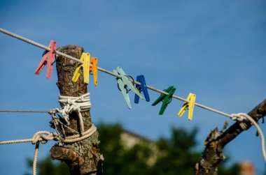 İpin arka planındaki renkli mandallar reklam için sokak yerinde bulanıklaştı