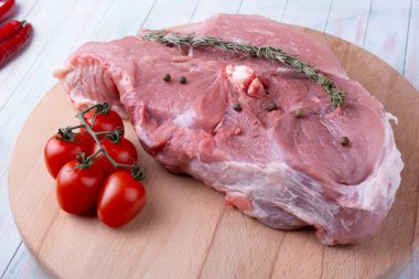 Kemiklerdeki et parçası, biberiye, domates, sarımsak ve baharatlar ahşap bir yuvarlak kesme tahtasındaki serbest alan yaratıcılığınız için yukarıdan görünüm