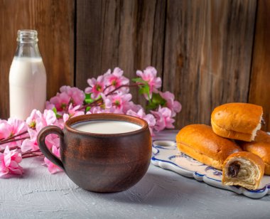 Çikolata dolgulu kahvaltı ruloları ve ahşap bir kırsal arka planda süt, yatay manzara