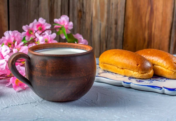 Breakfast rolls with chocolate filling and milk on a wooden rustic background, horizontal view