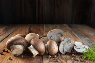 Kraliyet mantarları şampiyon ve parçalara ayrılmış, dağınık biberler, ahşap arka planda yakın plan, kırsal tarz, makro