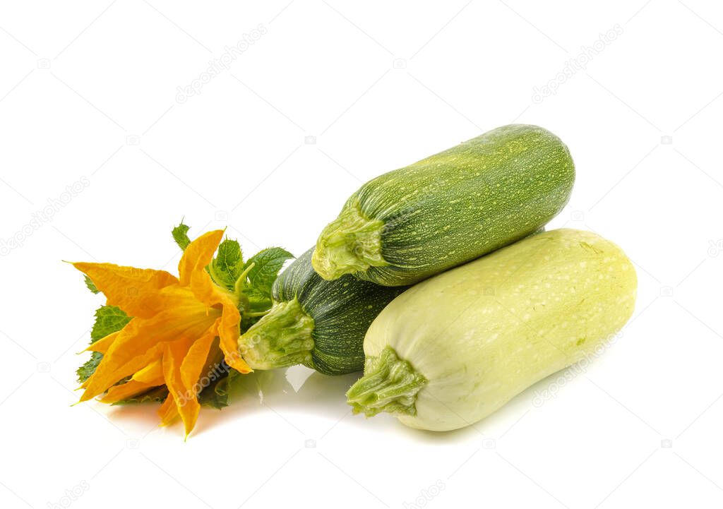 three fresh zucchini with green leaves and flower isolated on a white background,horizontal view