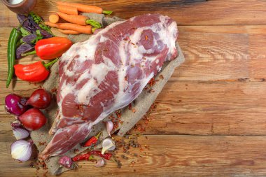 Çuval bezi, soğan, sarımsak, biber, tuz, biberiye ve sebze yağının üzerine işlenmemiş bir koyun bacağı. Yakın plan koyun eti. Taze bir koyun eti. Kırsal tarzda. Yukarıdan manzara. Makro.