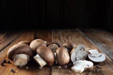 Kraliyet mantarları şampiyon ve parçalara ayrılmış, dağınık biberler, ahşap arka planda yakın plan, kırsal tarz, makro
